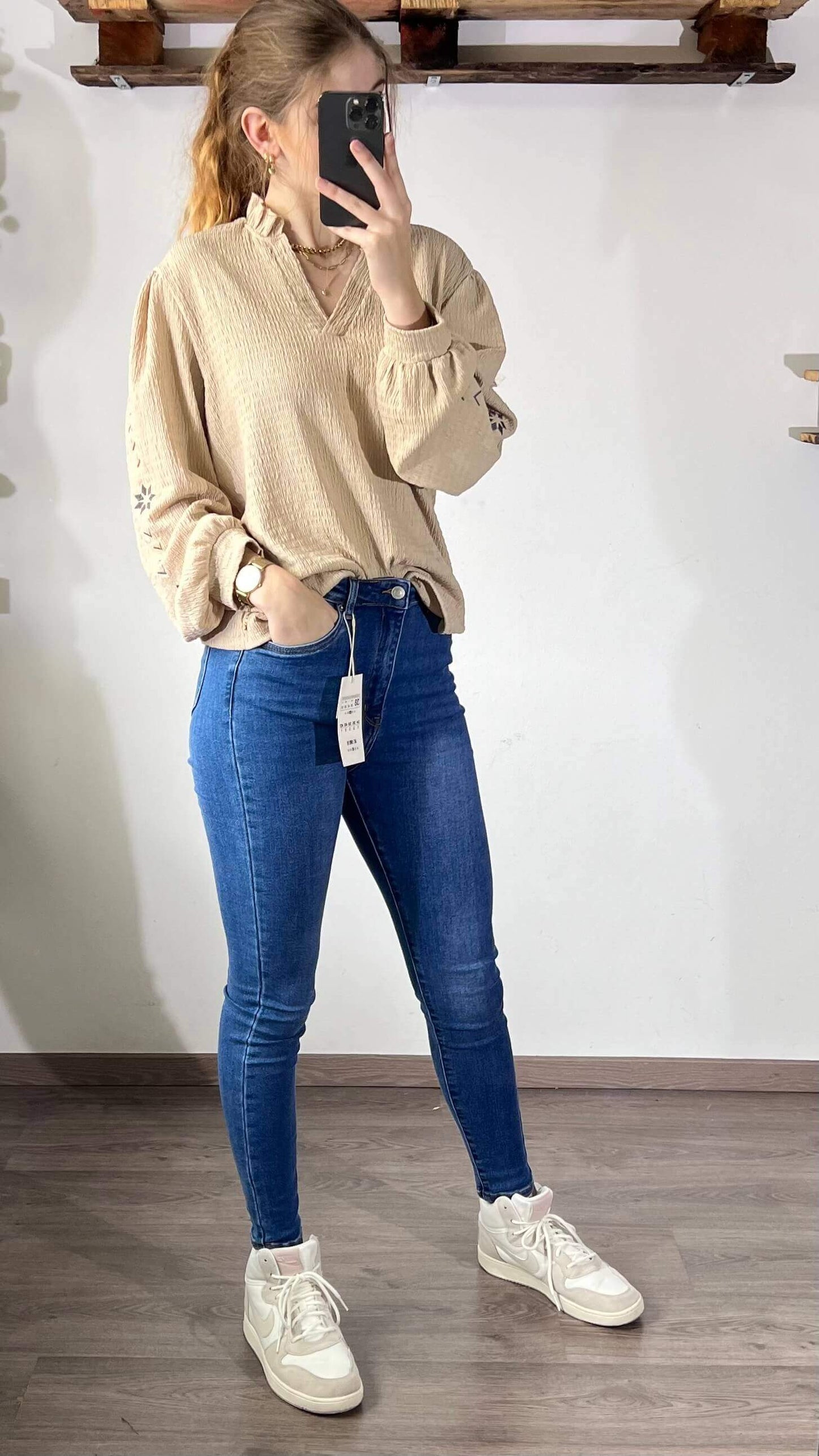 Beige blouse Milou, model in denim jeans met sneakers, casual stijl en comfort, perfect voor koude seizoenen.