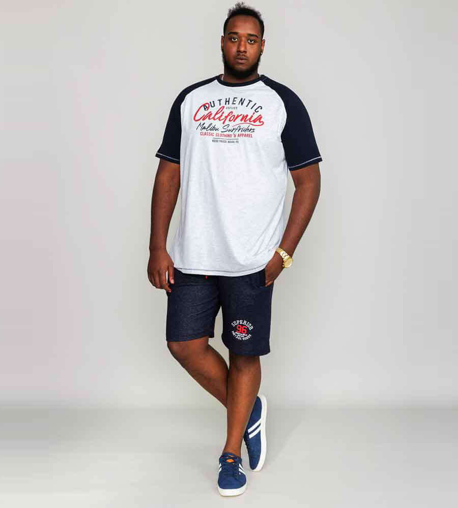 Man in heather grey raglan sleeve t-shirt with California print, paired with dark shorts and sporty shoes.