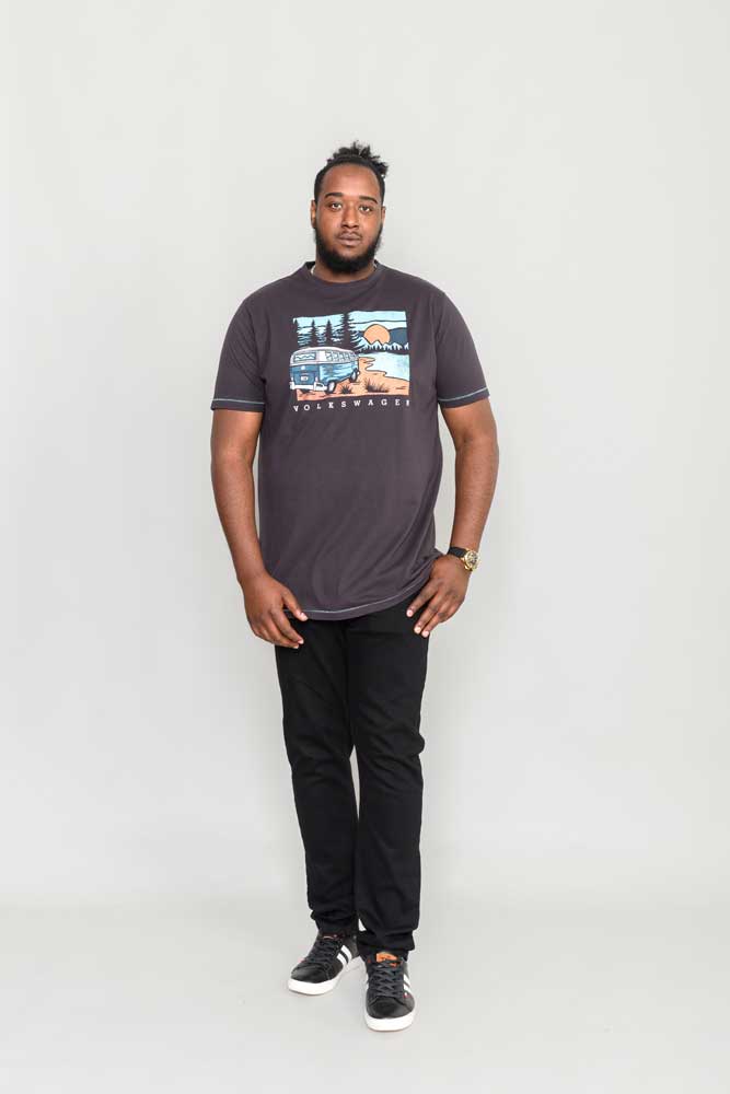 Man draagt een zwart Duke Clothing t-shirt met VW camper van print, casual outfit met zwarte broek.