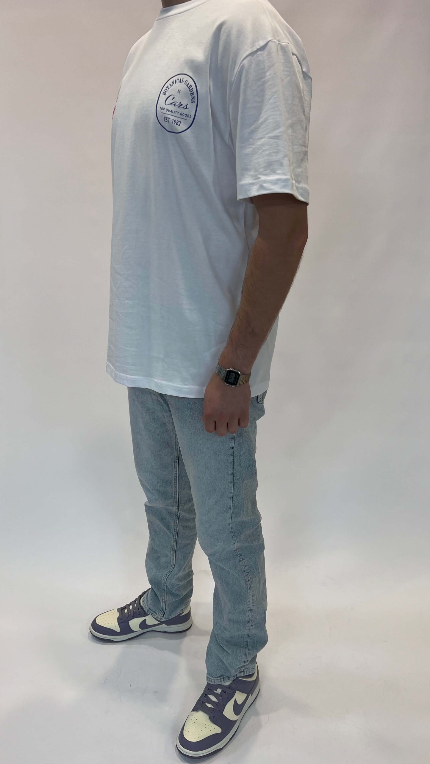 Man in losse fit Cars Jeans Guard stone jeans met witte T-shirt en sneakers.