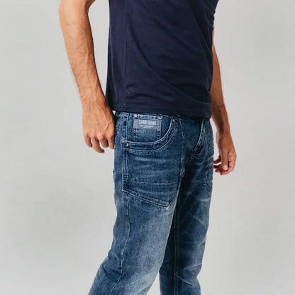 Model draagt Cars Jeans Bedford Stone Used stretch jeans met regular fit, in blauwe afgewassen kleur.