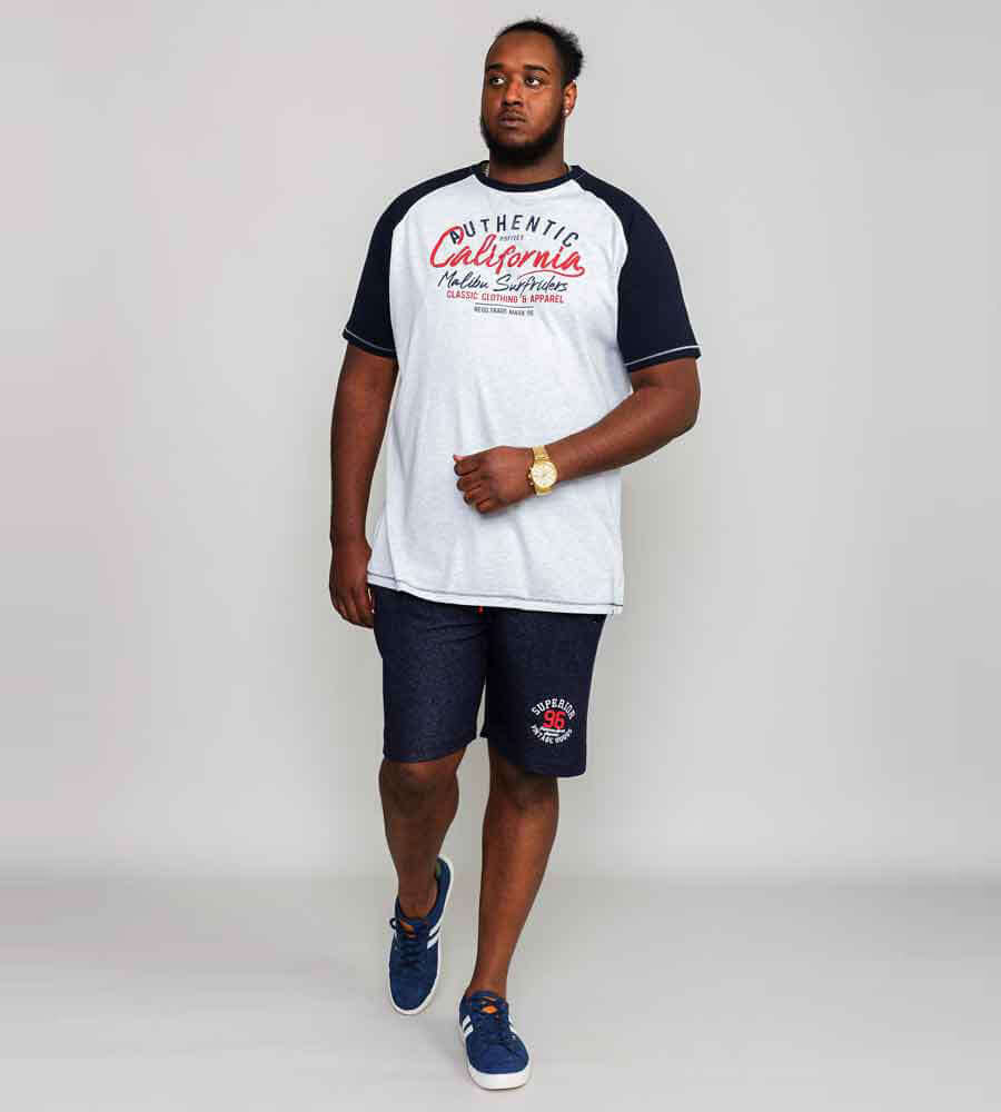 Man in een heather grey Duke Clothing SPARROW t-shirt met raglan mouwen en sportieve opdruk, gecombineerd met shorts.