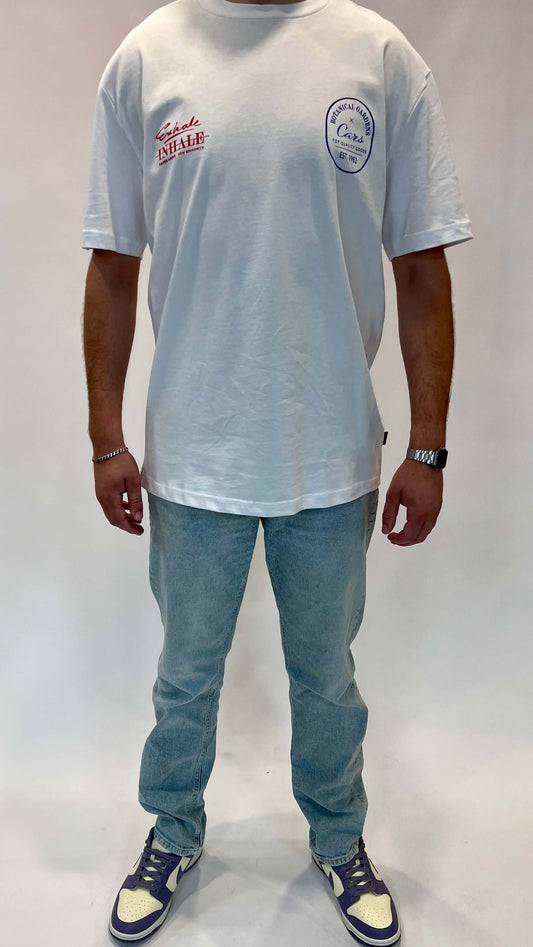 Fashionable man wearing a white Cars t-shirt and light blue jeans, showcasing a casual streetwear style.