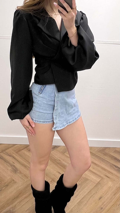 Modieuze denim skort in combinatie met een zwarte blouse, perfect voor een casual en stijlvolle look.
